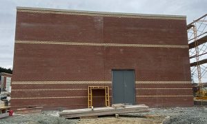 Dark red brick veneer on a factory building with solid plaster stripes