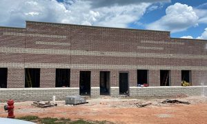 Face of dark brick masonry on a business building with white plaster stripes